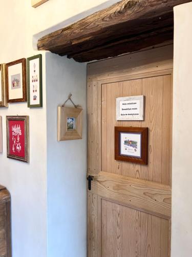 een houten deur in een kamer met foto's aan de muur bij Casa Agostini Bed and Breakfast in Farra di Soligo