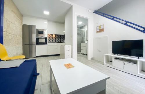 a living room with a white table and a tv at SOCAIRO in Cangas de Morrazo