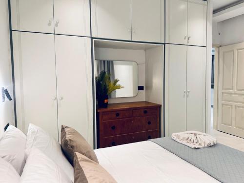 a bedroom with a bed with a mirror and a dresser at Mira Premium House - Serenity Escape in Kalamaki by Villa Mana Gers in Kalamaki