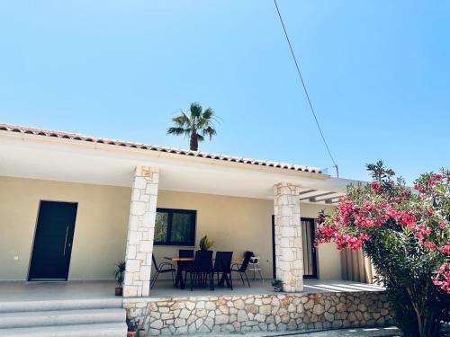 a house with a patio with a table and chairs at Mira Premium House - Serenity Escape in Kalamaki by Villa Mana Gers in Kalamaki