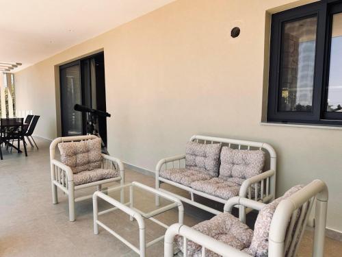 a living room with two chairs and a table at Mira Premium House - Serenity Escape in Kalamaki by Villa Mana Gers in Kalamaki
