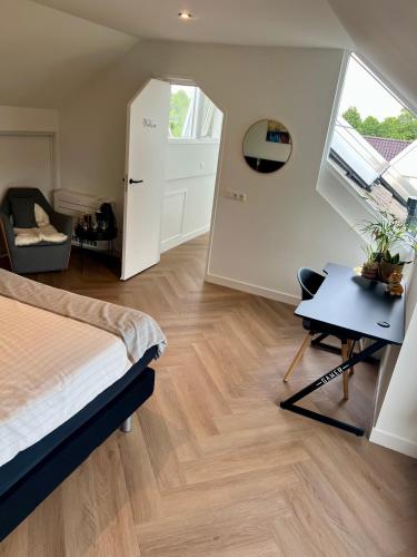 a bedroom with a bed and a desk and a window at Ruime slaap kamer met werkplek en privé badkamer Leeuwarden bij Jacqueline in Leeuwarden