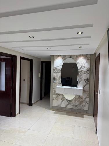 een lobby met een stenen muur met een spiegel bij Sweet Home Agadir Appartement moderne avec piscine et commerces à pied in Agadir