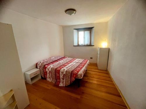 a small bedroom with a bed and a window at Baita Sostasio in Prato Carnico