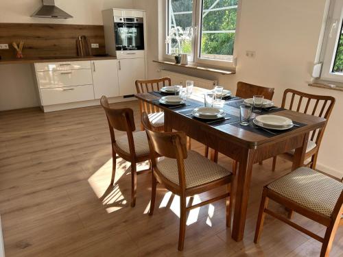 Un comedor con mesa y sillas de madera. en WALDnah Rückzugsort in Haiterbach, en Haiterbach