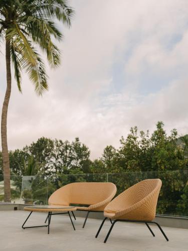 two chairs and a coffee table on a patio at ORO The Estates, Nandi Hills in Nandigunda