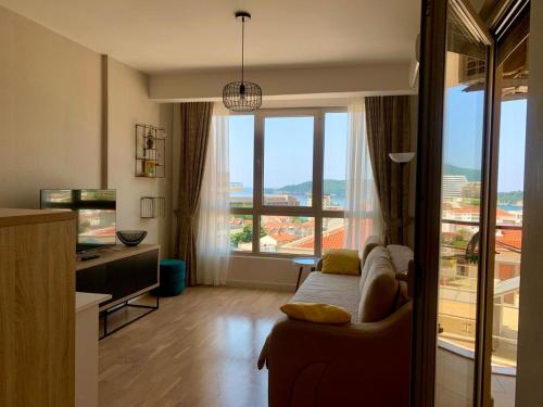 a living room with a bed and a large window at Apartment Becici in Becici
