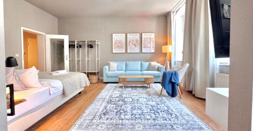 a bedroom with a bed and a blue couch at Amber & Air - 2 Schlafbereiche, Altstadtnähe, WLAN & Parkplatz in Freiberg