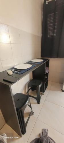 a black desk with a stool in a room at Kitnet 17a in São Luís