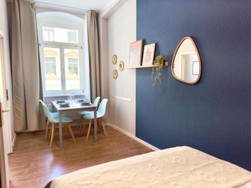 a room with a table and chairs and a mirror at Amber & Air - 2 Schlafbereiche, Altstadtnähe, WLAN & Parkplatz in Freiberg