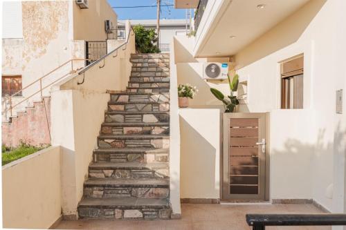 a staircase leading up to a house with a door at Cozy Guesthouse in Koskinou