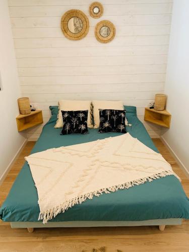 a bedroom with a large bed with blue sheets and pillows at Logement cosy en centre ville in Talmont