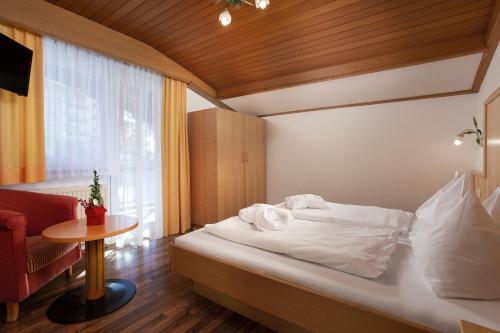 a hotel room with a bed and a table at Hotel Tannenberg in Saalbach Hinterglemm