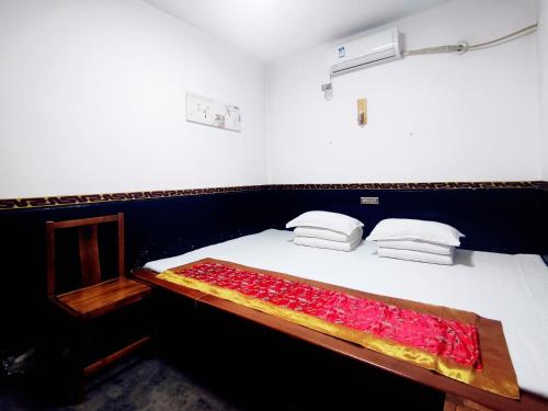 a bedroom with a bed with a red blanket on it at Pingyao Xiangshengyuan Guest House in Pingyao