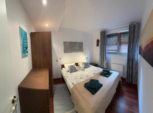 a small bedroom with a bed and a window at Apartament Willa Woda in Jurata
