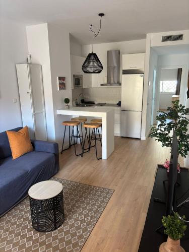 a living room with a blue couch and a kitchen at Casa Dalia - One bedroom flat in Torremolinos