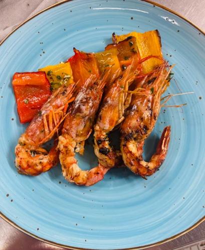 a blue plate with shrimp and vegetables on a table at Blumarin in Lido di Jesolo