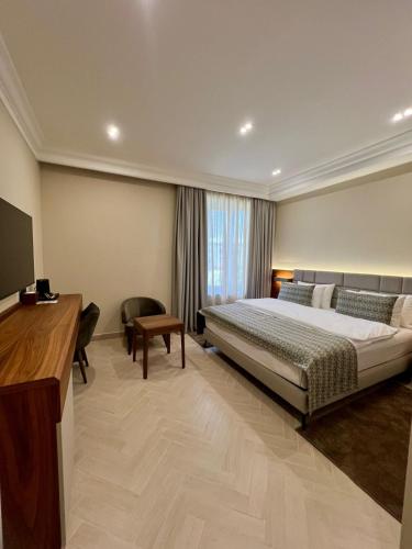 a hotel room with a bed and a desk at Plaza Viktoria Hotel Yerevan in Yerevan