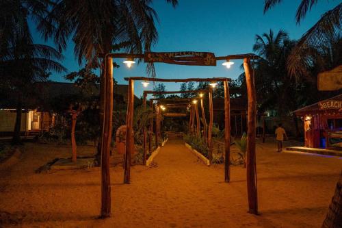 a wooden arch with lights on a beach at night at Mithra Paradise Beach Hotel in Nilaveli