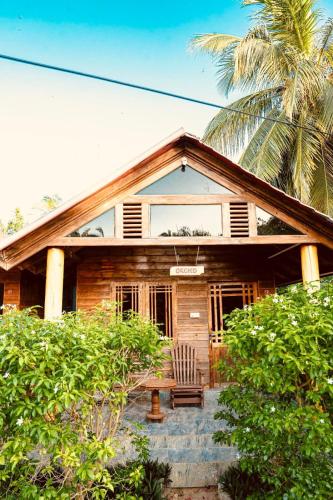 a house with a chair and a bench in front of it at Mithra Paradise Beach Hotel in Nilaveli