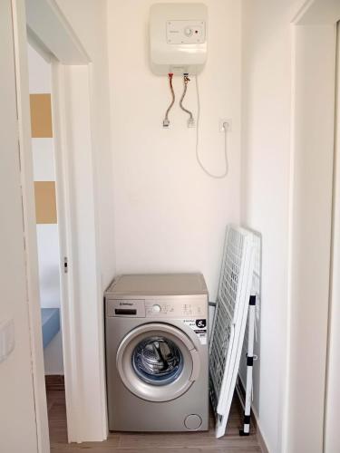 a laundry room with a washing machine in a hallway at Appartamenti Praia Estoril, Sal Rei, Boa Vista in Sal Rei