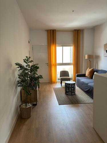 a living room with a blue couch and a plant at Casa Dalia - One bedroom flat in Torremolinos