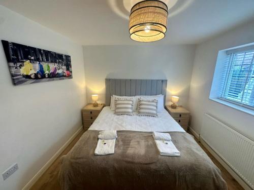 a bedroom with a bed with two towels on it at Spacious and Welcoming one-bedroom apartment in Sunningwell