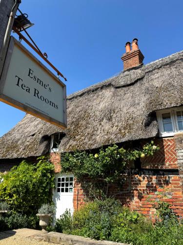 an old brick building with a thatched roof at Thatched Cottage Hotel in Brockenhurst
