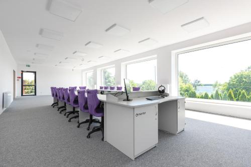 an office with a row of purple chairs and a desk at Blue&Green Masurian Hotel in Węgorzewo
