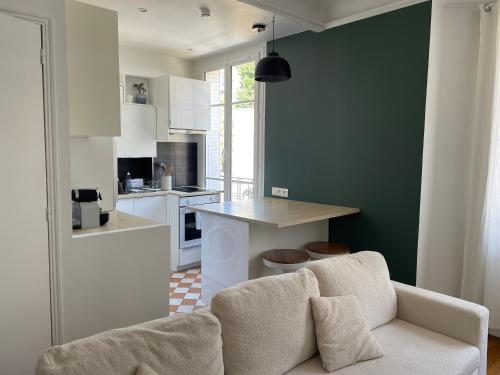 un salon avec un canapé et une cuisine dans l'établissement Cosy 2 pièces 1 Chambre , 1 séjour, et 1 coin bureau, à Boulogne-Billancourt
