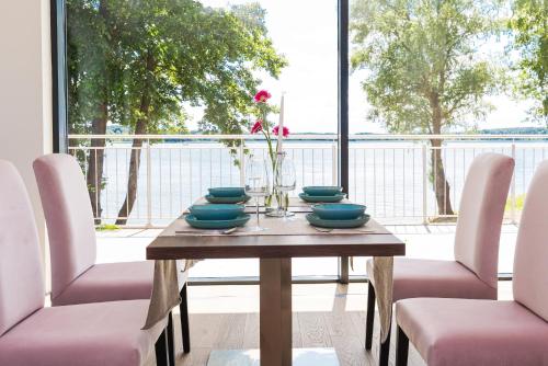 a table with chairs and a vase with flowers on it at Blue&Green Masurian Hotel in Węgorzewo