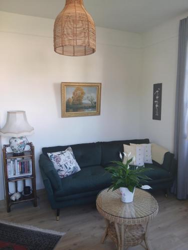 a living room with a green couch and a table at Meublé tout confort à la campagne in Uhrwiller