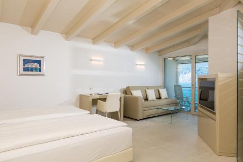 a bedroom with a bed and a living room at Hotel Vega in Malcesine