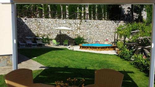 a backyard with a pool and a table and chairs at Villa Talea in SantʼAgata sui Due Golfi