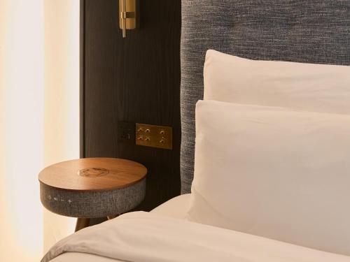 a bedroom with a bed and a table next to a bed at Public House Bangkok, a Member of Design Hotels in Bangkok