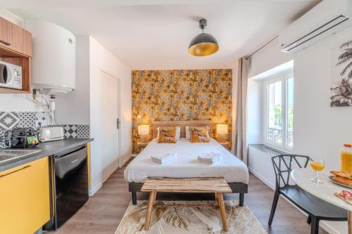 une chambre avec un lit et une table et une cuisine dans l'établissement Lys Roanne centre-ville - Clim & Parking, à Roanne