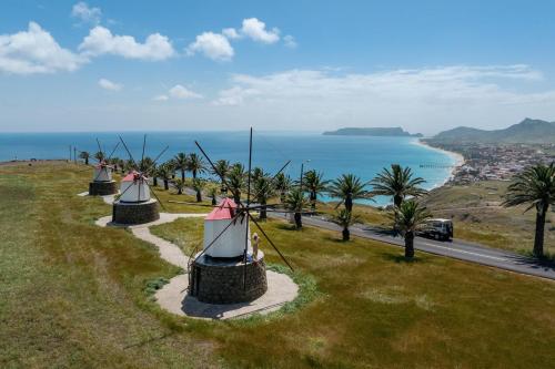 a group of tents on a grassy hill with the ocean at Barlavento by An Island Apart in Porto Santo