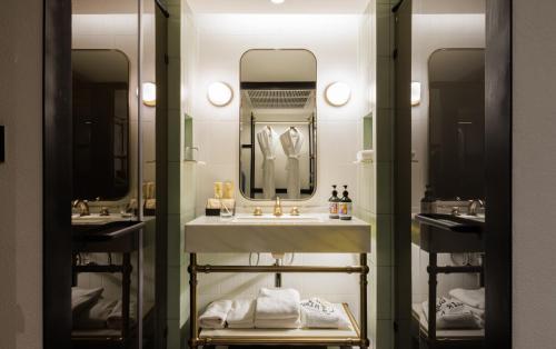 a bathroom with two sinks and two mirrors at Public House Bangkok, a Member of Design Hotels in Bangkok