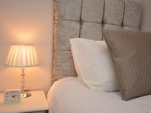 a bed with a headboard and a lamp on a table at 4 Bed in Oswestry 74110 in Kinnerley