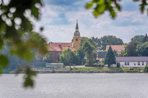 a large building with a clock tower next to a lake at Eurocamp Spreewaldtor in Groß Leuthen