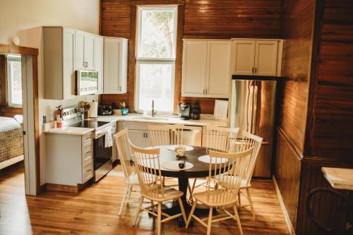 a kitchen with a table and chairs and a refrigerator at Corton Lodge Bell Tower Suite Private Riverfront in Clendenin
