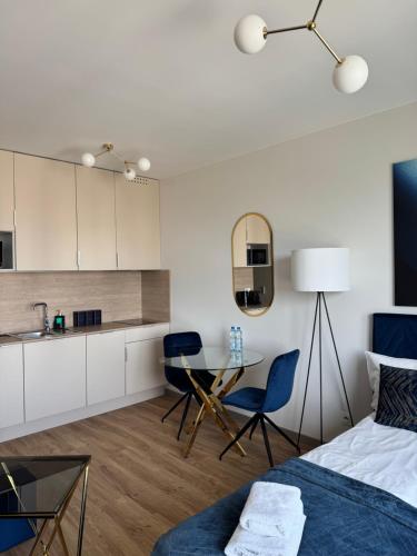 a bedroom with a bed and a table and a kitchen at AboutArtApartments - Otyńska 4 in Wrocław