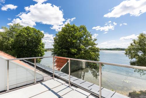 a balcony with a view of the water at Blue&Green Masurian Hotel in Węgorzewo