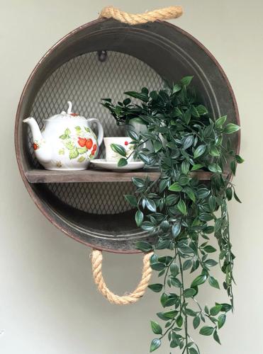 a shelf with a potted plant and a tea pot at Thatched Cottage Hotel in Brockenhurst