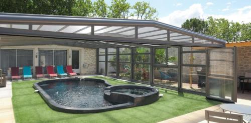 a patio with a hot tub in the middle of a yard at Le logis de la castagne in Caumont-sur-Durance
