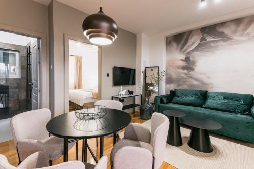 a living room with a green couch and chairs at Calidum Boutique Suites in Šibenik