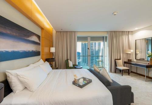 ein Hotelzimmer mit großem Bett und Schreibtisch in der Unterkunft Kempinski Central Avenue Residence - Direct Access Dubai Mall in Dubai