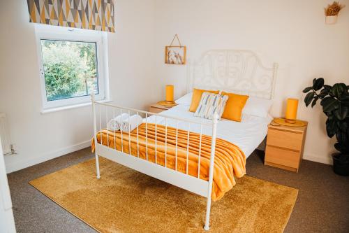 カーディフにあるCosy Stays Cardiffのベッドルーム(白いベッド、オレンジの毛布付)