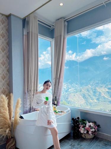a woman standing in a bath tub with a window at Mường Hoa Valle Home in Sa Pa