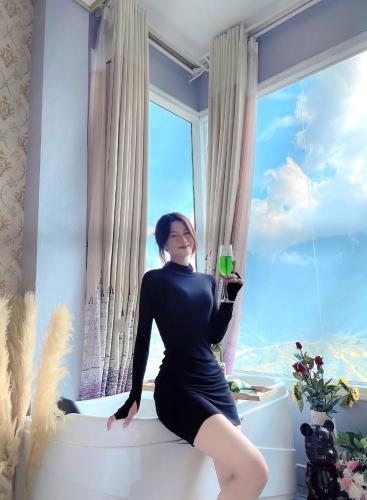 a woman sitting on a window ledge holding a wine glass at Mường Hoa Valle Home in Sa Pa